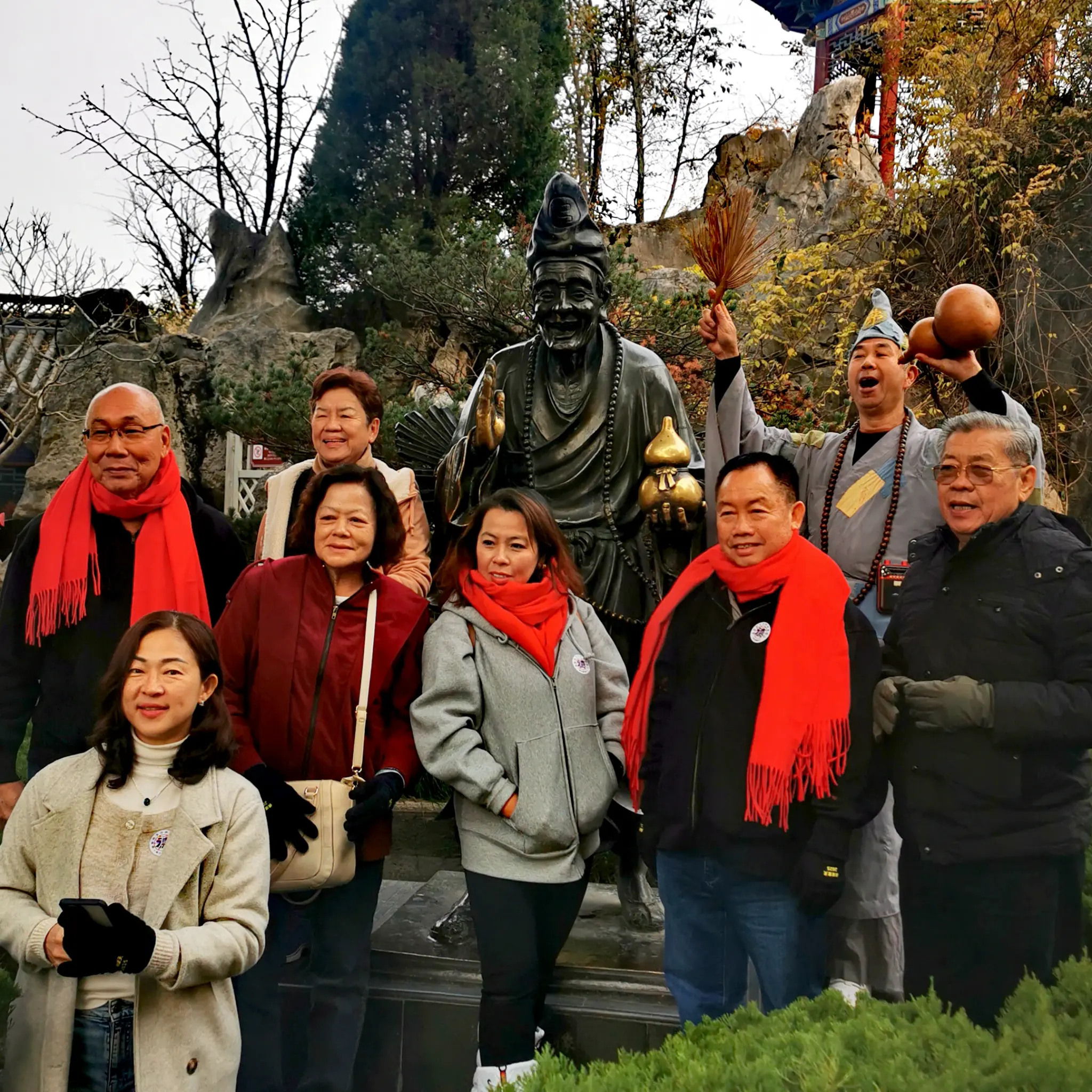 Retreat visitors gathered beside a Buddhist statue during a shared journey